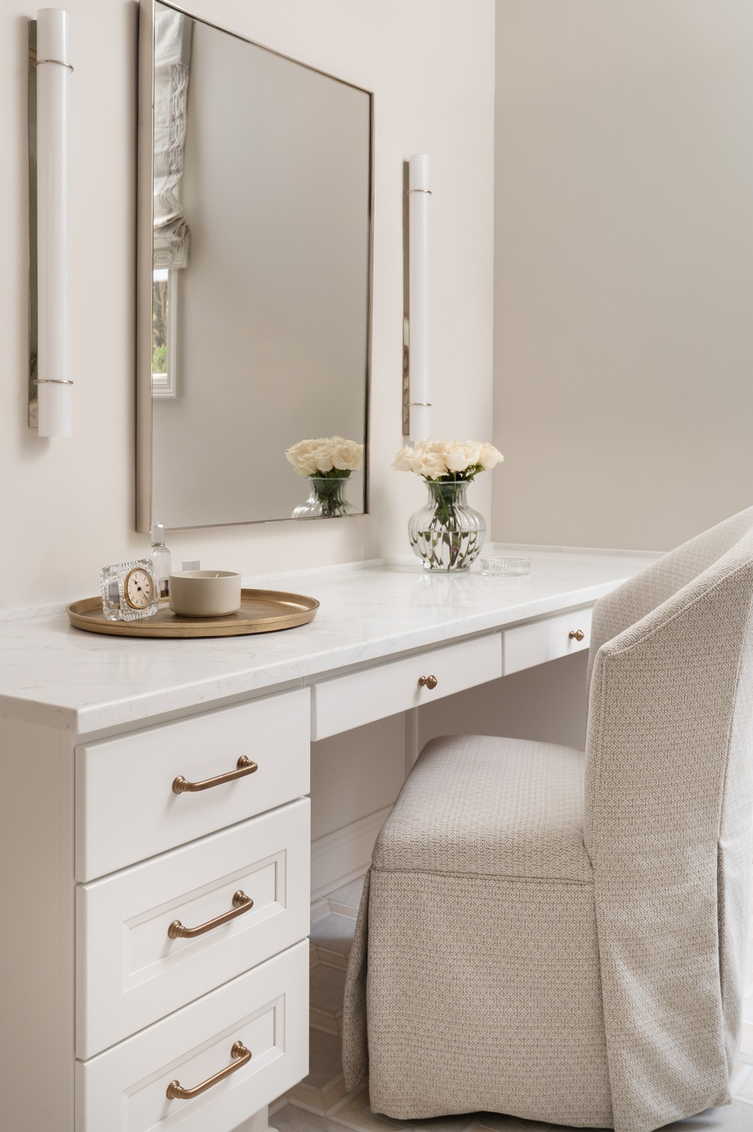Built in makeup vanity with upholstered chair and mirror in Michiana primary bathroom remodel