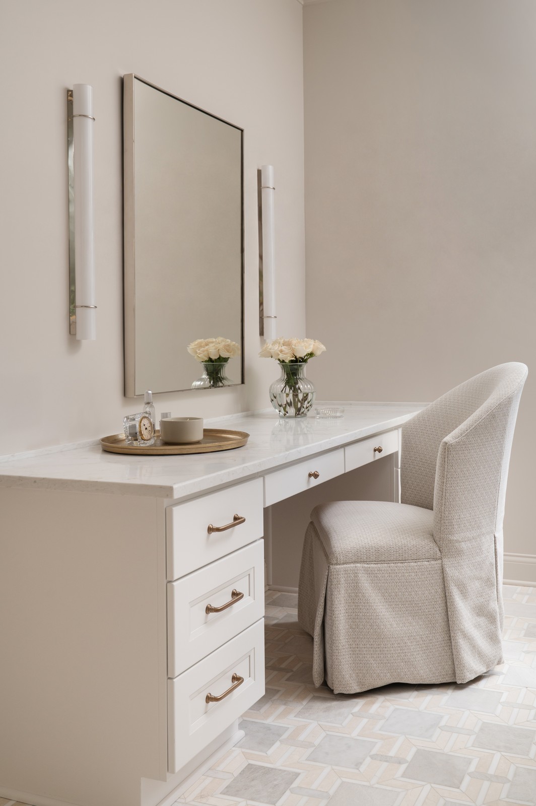 Makeup vanity desk with skirted chair and brass sconces in Michiana primary bathroom remodel