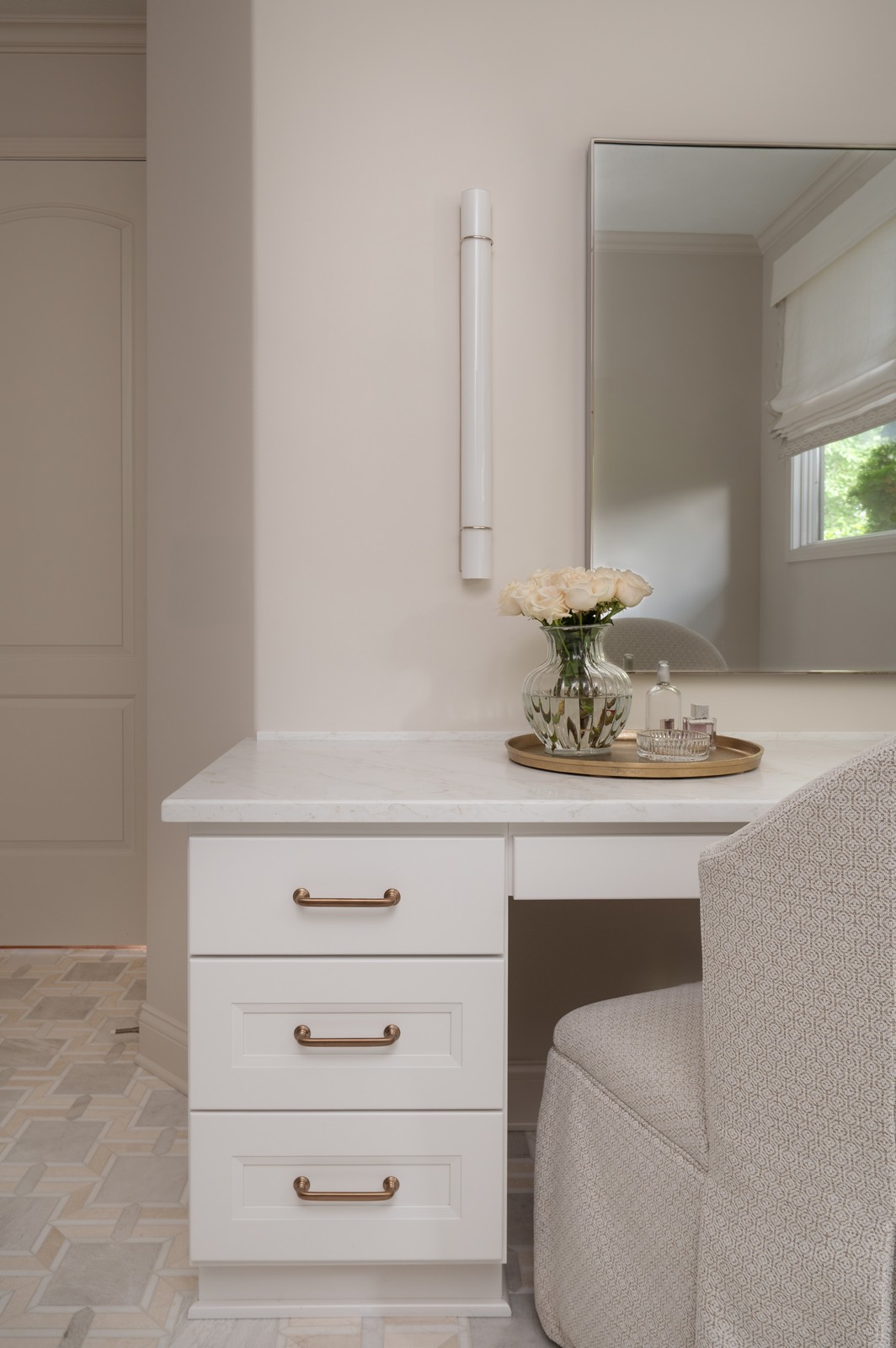 Makeup vanity drawers with brass pulls and mirror reflection in Michiana primary bathroom