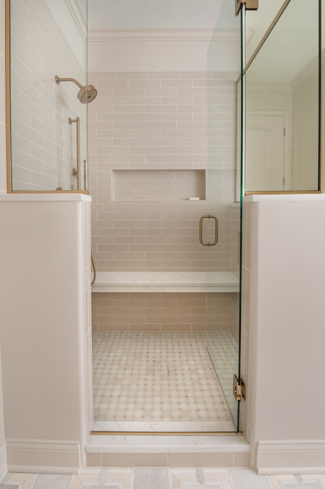View through open shower door into tiled walk in shower in Michiana primary bathroom, designed by Peacock and Co