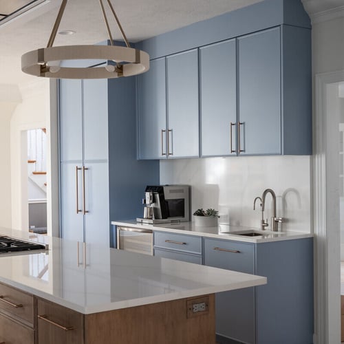 Blue high-end kitchen remodel in South Bend, IN with island and cooktop by Peacock &amp; Company