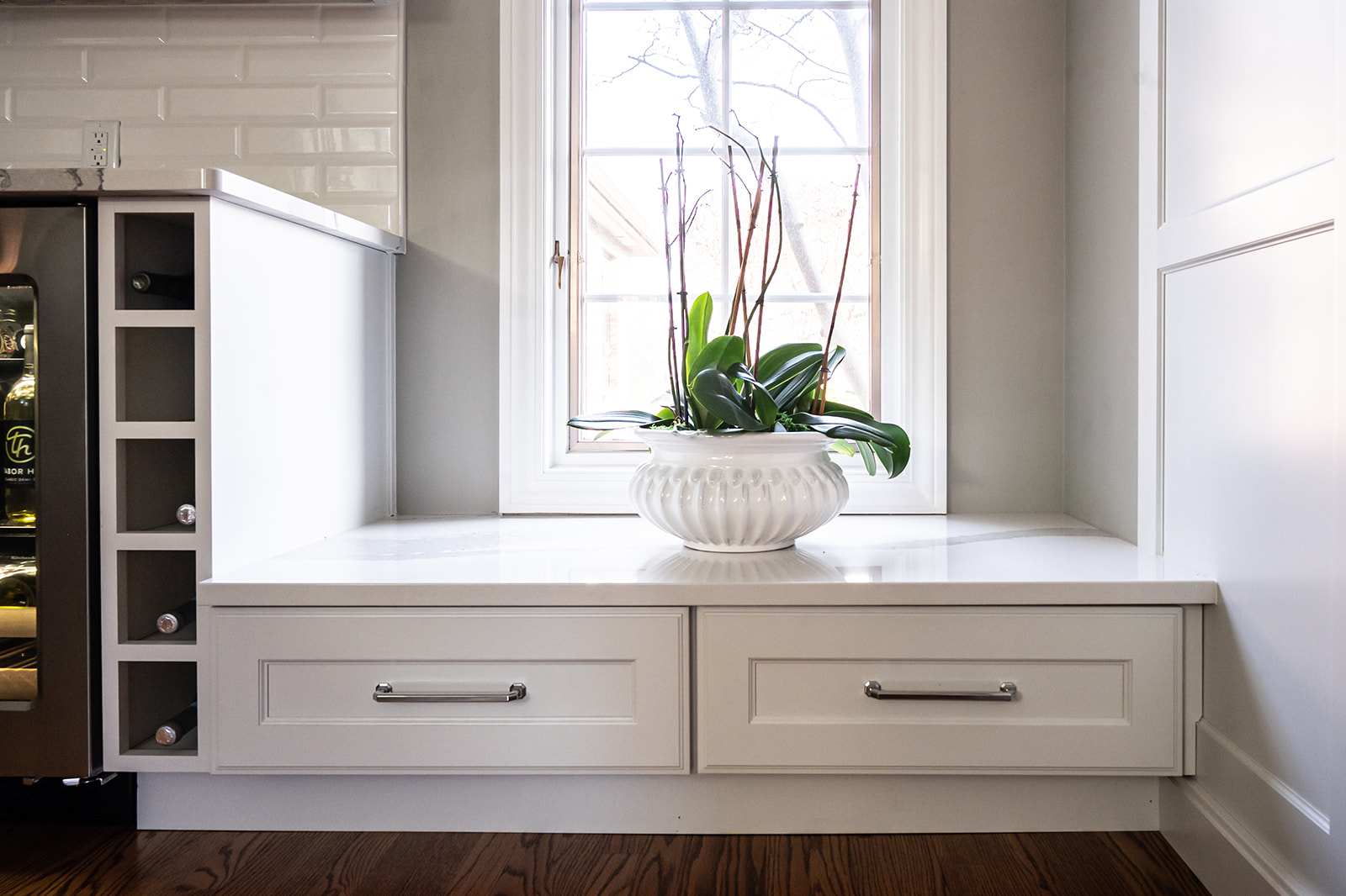 Lowered Double Kitchen Drawers Beneath Window Next to Built-In Wine Bottle Holder
