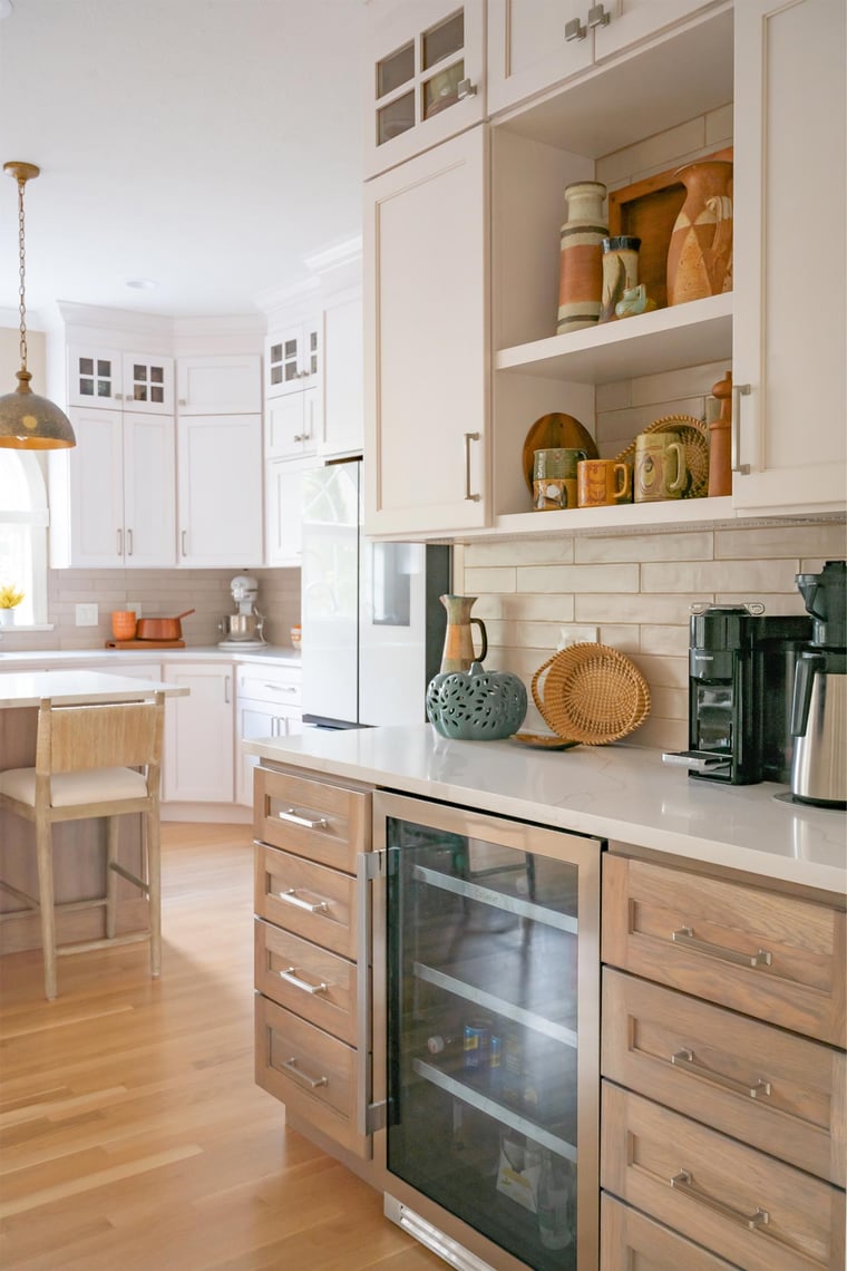 Modern kitchen in Bristol, IN with white cabinetry, wood floors, and glass-front beverage cooler