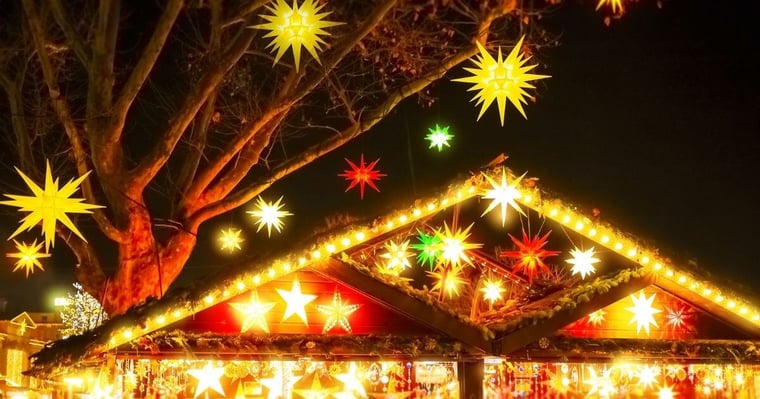 Christmas lights hanging from tree at holiday market at night