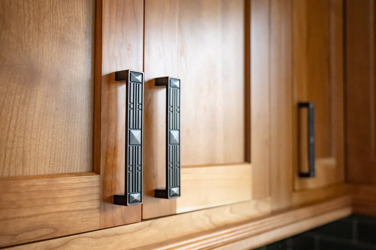Close up of oil rubbed bronze cabinet pulls on cherry shaker cabinets in kitchen remodel by Peacock & Co in South Bend