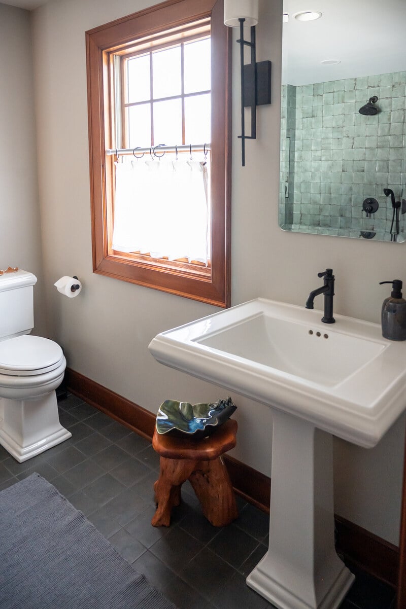 water closet view of 3/4 bathroom remodel in South Bend by Peacock and Co with pedestal sink and custom tile