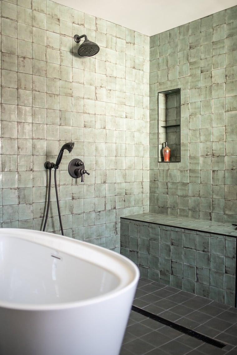 Custom tile and built-in shelving in walk-in shower in bathroom remodel with oil-rubbed bronze hardware in Peacock and Co