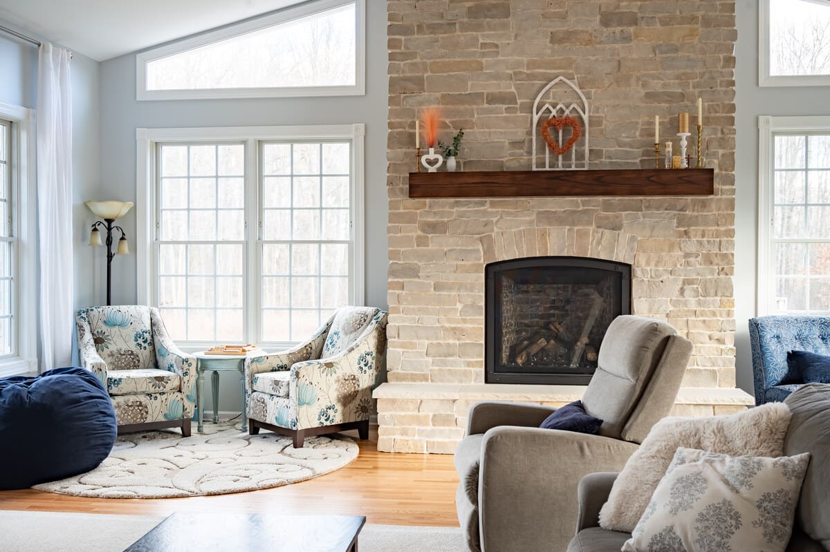 Four-season sunroom with brick fireplace and large windows by Peacock & Company in South Bend