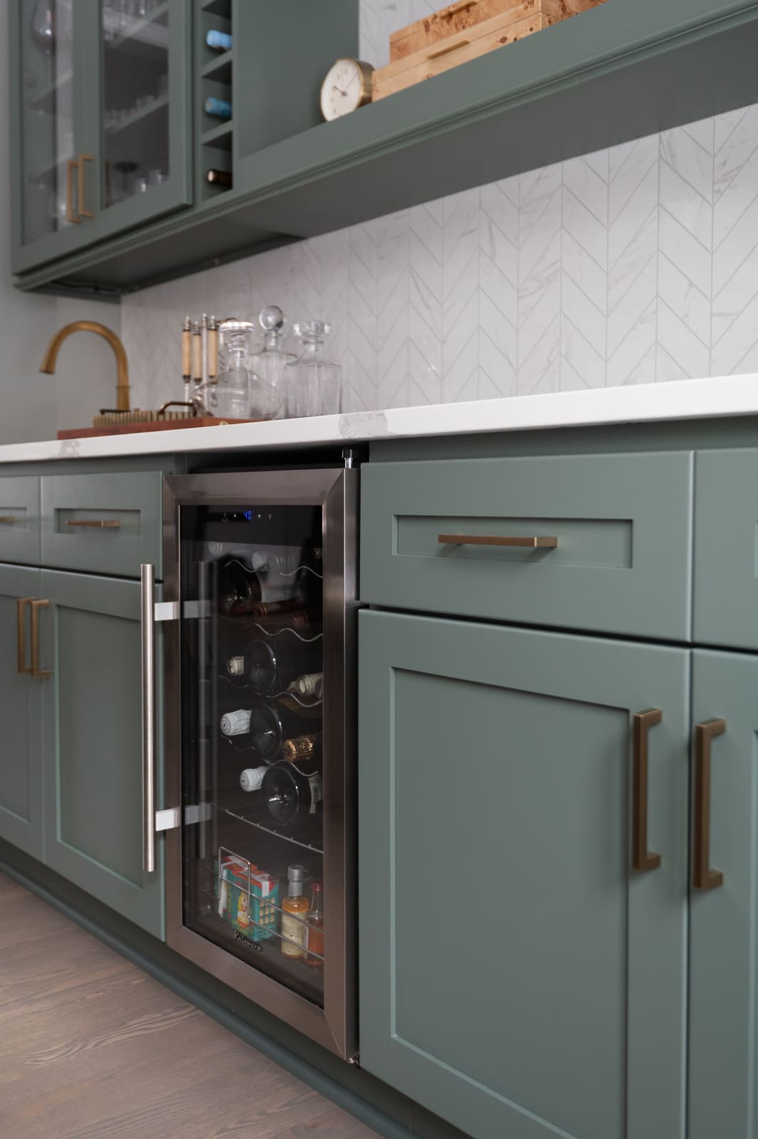 Beverage fridge with sage green cabinets, brass hardware, and white quartz counters in a Granger, IN kitchen