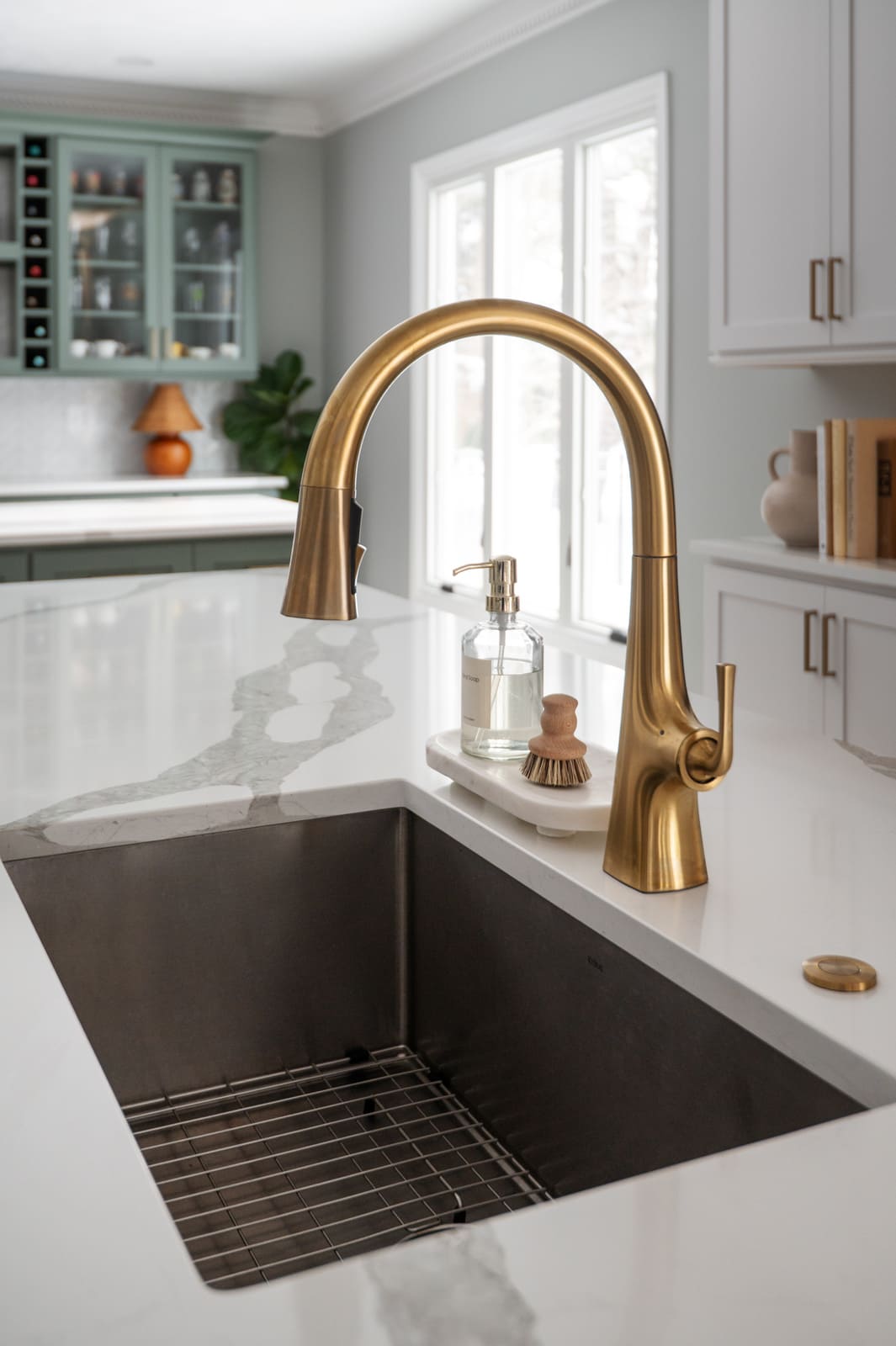 Brass kitchen faucet and deep sink on a white island with quartz counters in a Granger, IN kitchen