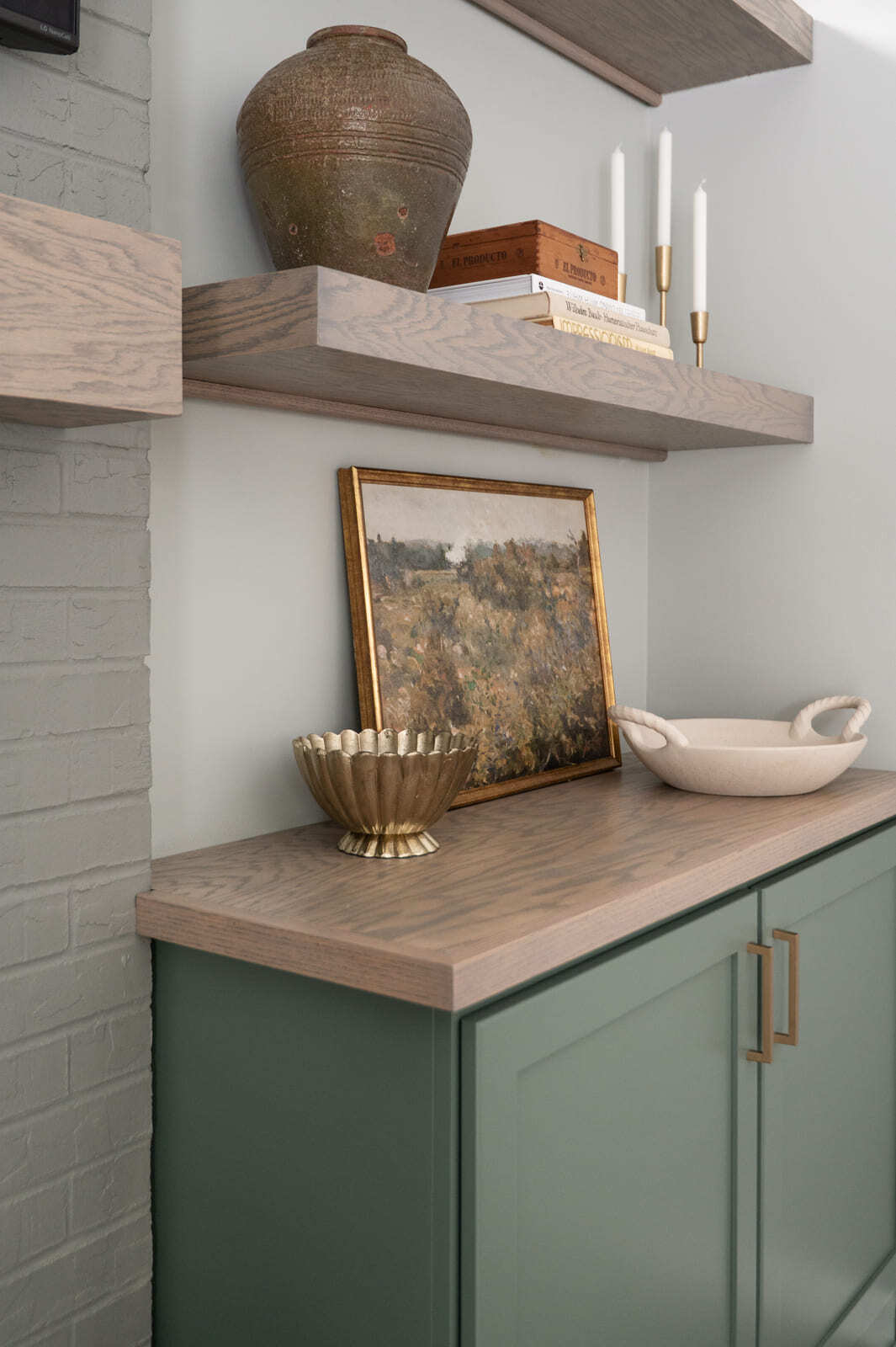 Close-up of wood shelves and decor above a sage green built-in cabinet in Granger, IN
