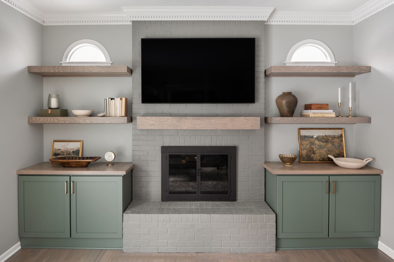 Granger, IN living room with sage green built-ins, wood shelves, gray brick fireplace, and wall-mounted TV