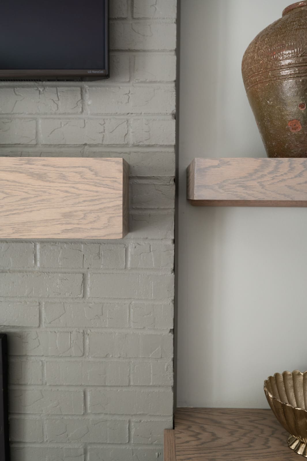 Painted brick fireplace and wood mantel beside built-in shelving and decor in a Granger, IN living room