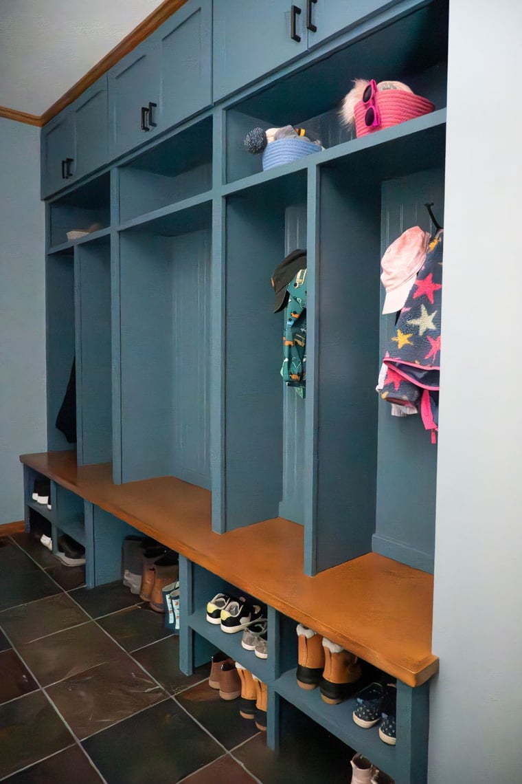 Blue built-in mudroom lockers with wood bench and slate tile floor located in Indiana