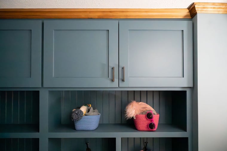 Built-in blue storage cabinets with wood trim and baskets located in Granger, IN
