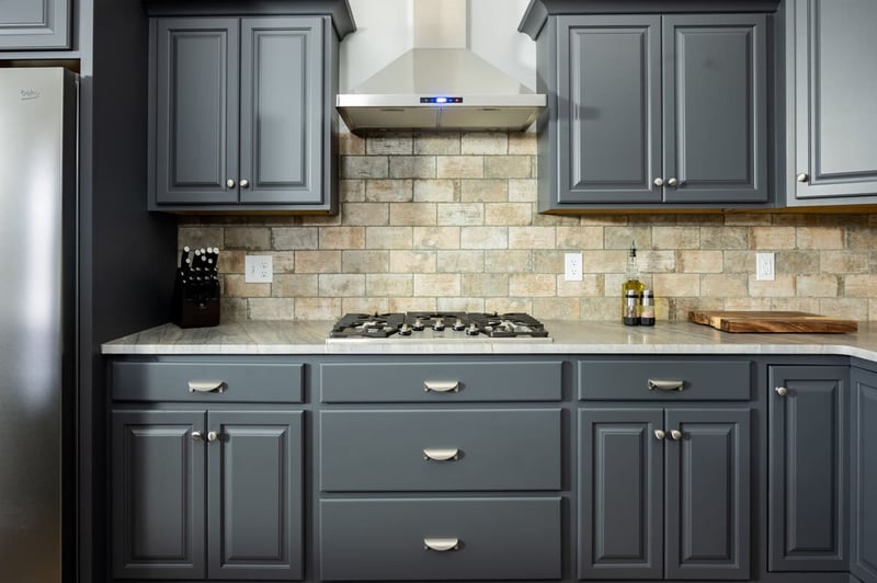 Gray shaker kitchen cabinets in South Bend kitchen remodel with brick backsplash and outlets
