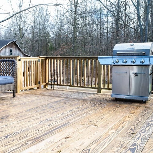 Grill and outdoor furniture on wood deck by Peacock and Company