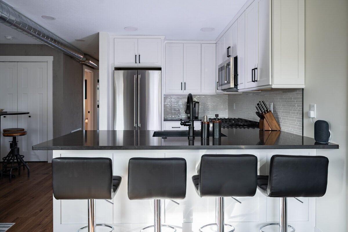 Condo kitchen remodel with open-concept kitchen and peninsula island with seating by Peacock & Company