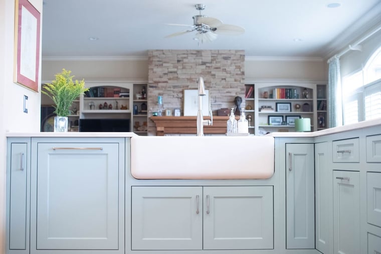 Light blue shaker style cabinets in kitchen island with white farmhouse sink