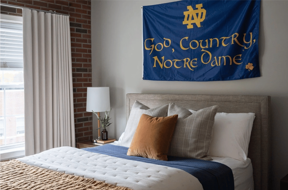 Notre Dame flag hanging over a bed.