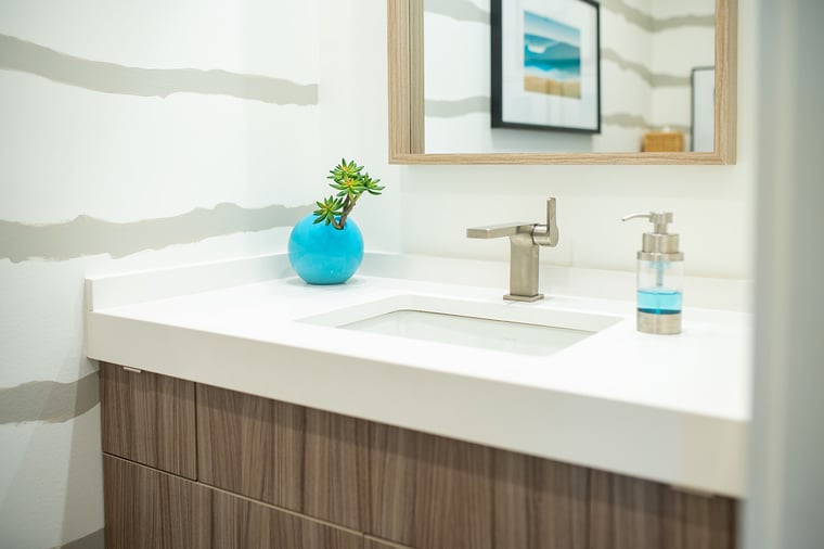 Minimalist bathroom vanity with wood cabinetry, white countertop, and modern fixtures in South Haven, MI
