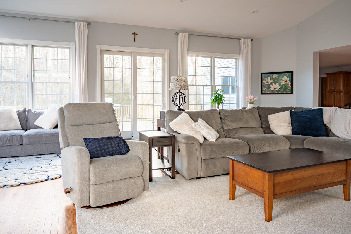 Recliner and couch in sunroom addition by Peacock & Company