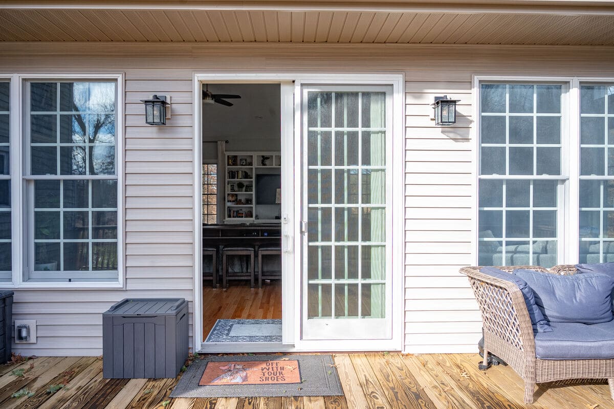 Sliding glass door open to inside of home from deck by Peacock and Company