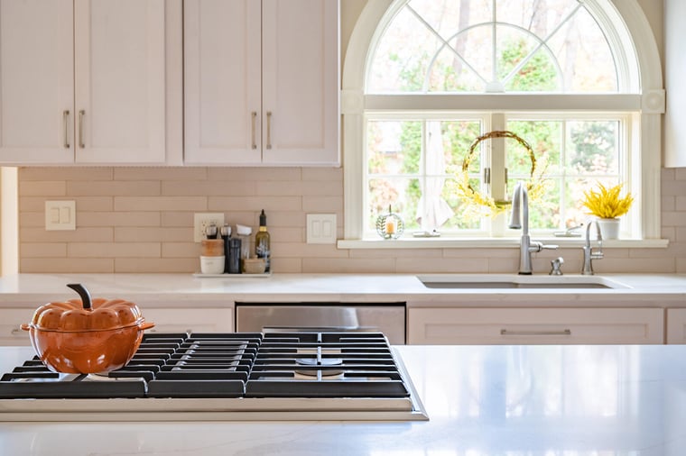 Stovetop on island and window behind sink in South Bend, IN kitchen remodel by Peacock & Company