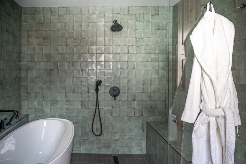 Tub and shower with white robe hanging in South Bend, IN bathroom remodel by Peacock and Company