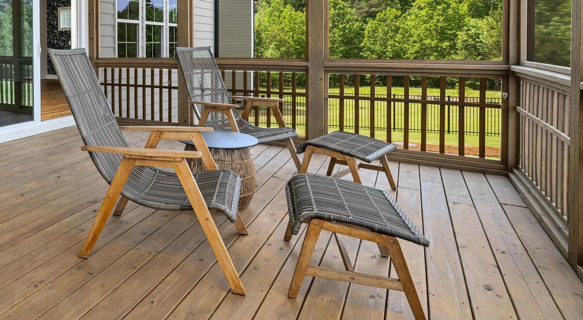 Two chairs with foot rests in front inside screened-in porch on sunny day
