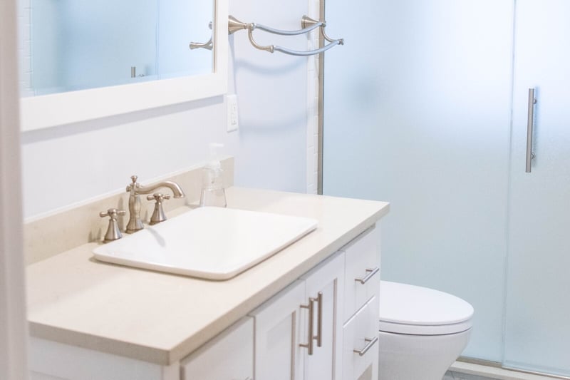Bathroom sink with brass fixtures and walk-in shower