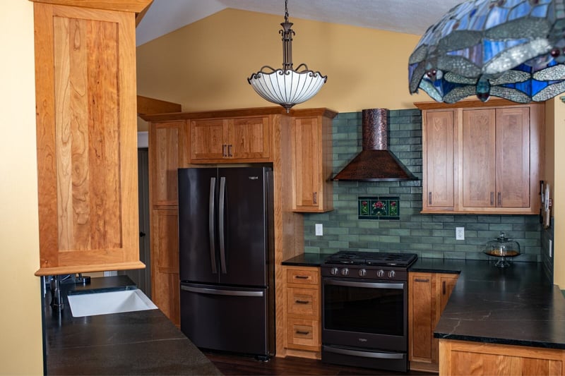 Craftsman dark wood cabinets and green subway tile backsplash kitchen range hood