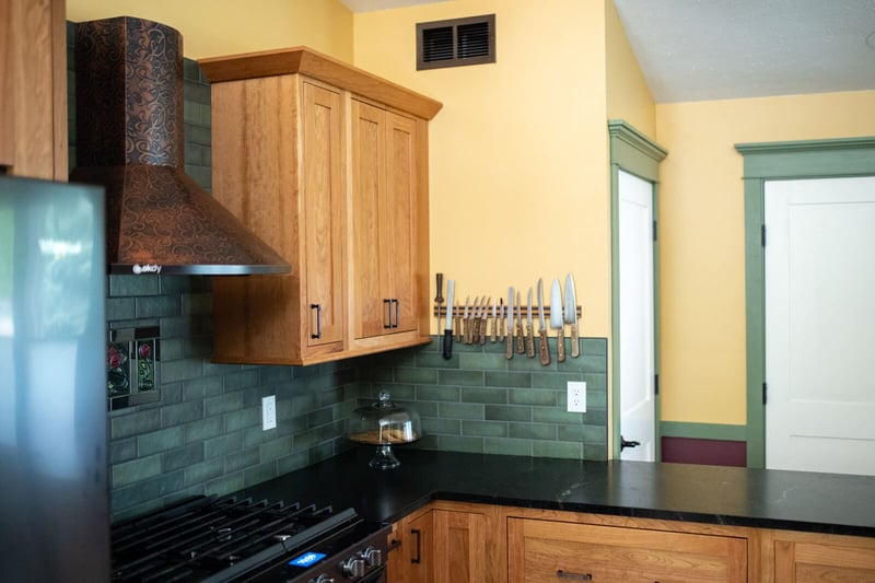 Craftsman-style kitchen remodel with green tile backsplash and wood cabinets