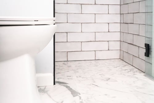 Curbless walk-in shower in bathroom remodel with subway tiling