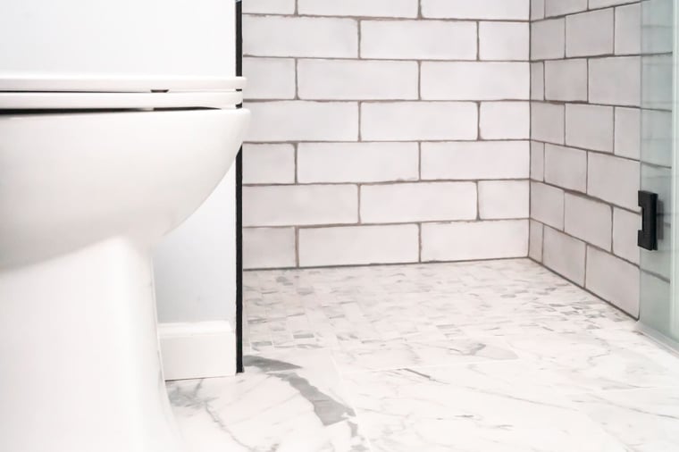 Curbless walk-in shower in bathroom remodel with subway tiling