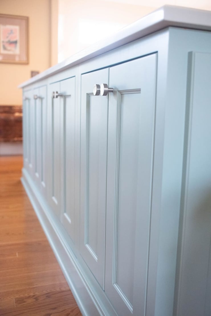 Light blue shaker cabinets in kitchen remodel with knob pulls