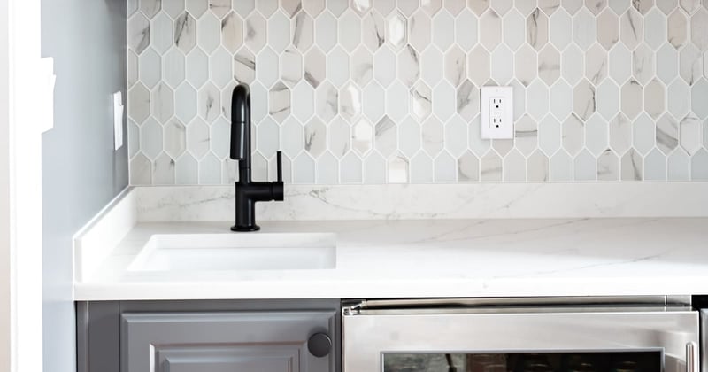 Modern beverage station with built-in fridge and under mount sink with black faucet