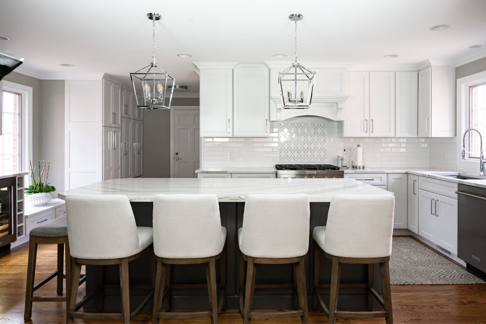 white kitchen with island and bar stools pendant lighting