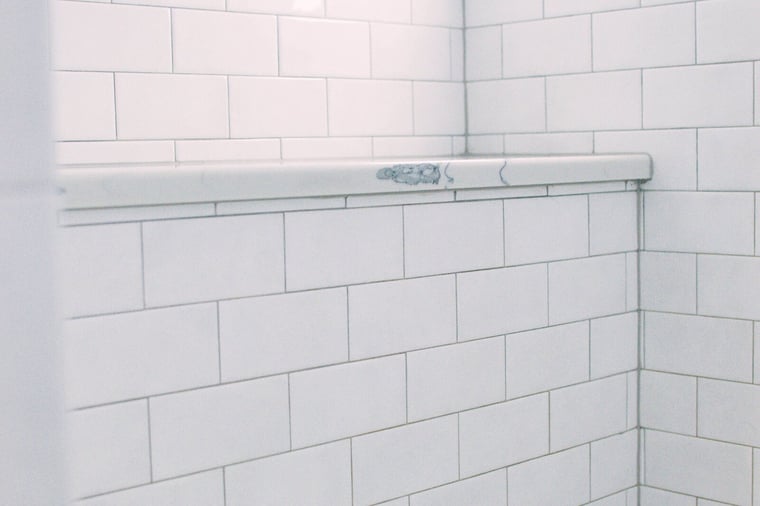 white subway tiling and seat in shower of bath remodel